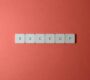 Free Close-up of keyboard keys spelling 'BACKUP' placed on a coral-colored surface. Stock Photo